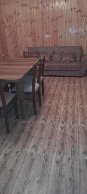 a living room with a wooden table and a couch at Marekhi guest house in Sagarejo