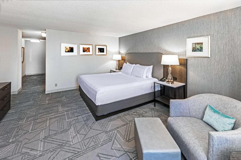 タルサにあるDoubleTree by Hilton Tulsa Downtownのベッドとソファ付きのホテルルーム