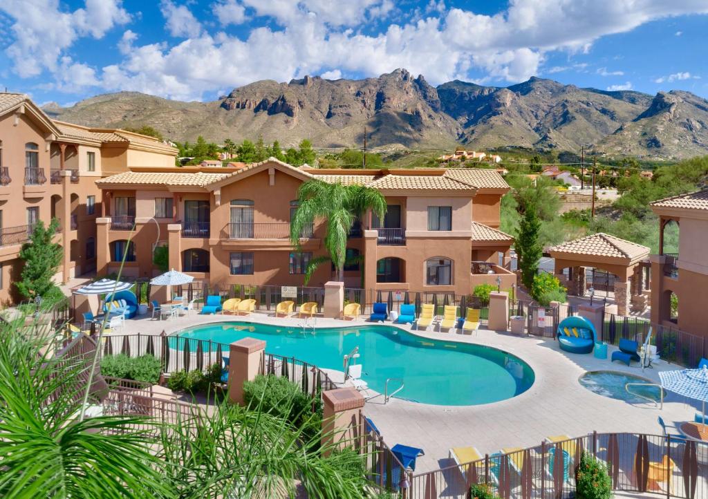 a view of a resort with a swimming pool and mountains at Embassy Suites Tucson - Paloma Village in Tucson