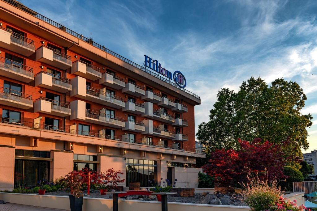 a hotel building with a sign on top of it at Hilton Evian Les Bains in Évian-les-Bains