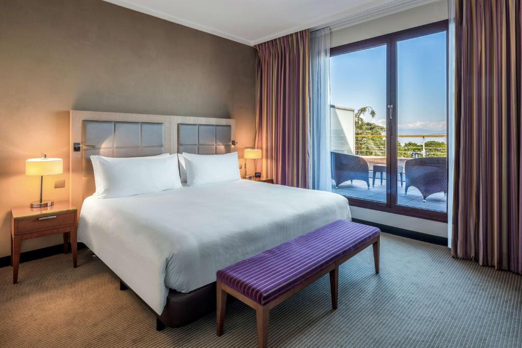 a bedroom with a large bed and a large window at Hilton Evian Les Bains in Évian-les-Bains