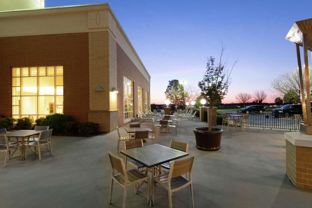 a patio with tables and chairs in front of a building at Embassy Suites Northwest Arkansas - Hotel, Spa & Convention Center in Rogers