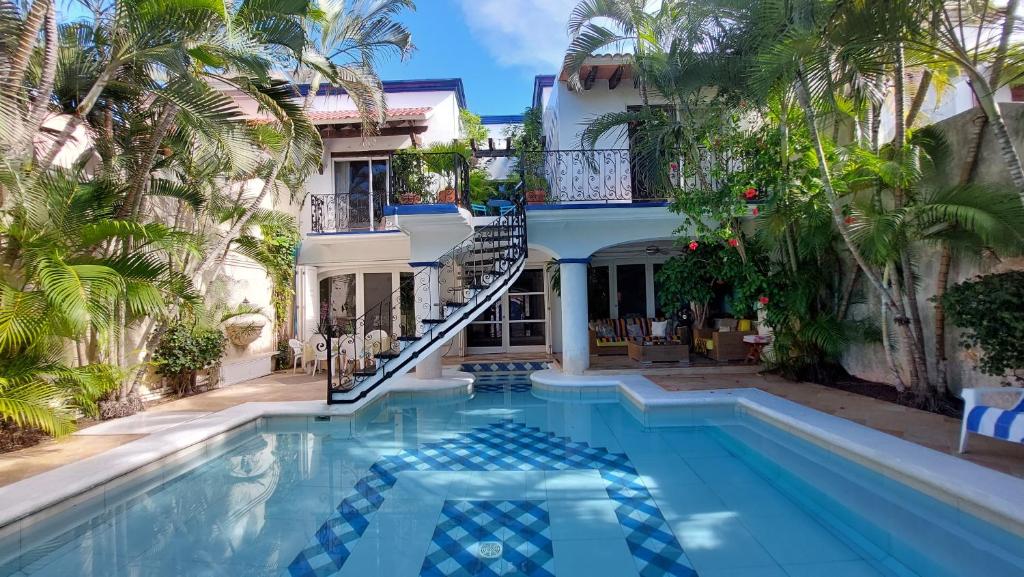 a swimming pool in front of a house with a staircase at La Villa du Golf &agrave; Cancun Hotel Boutique in Canc&uacute;n