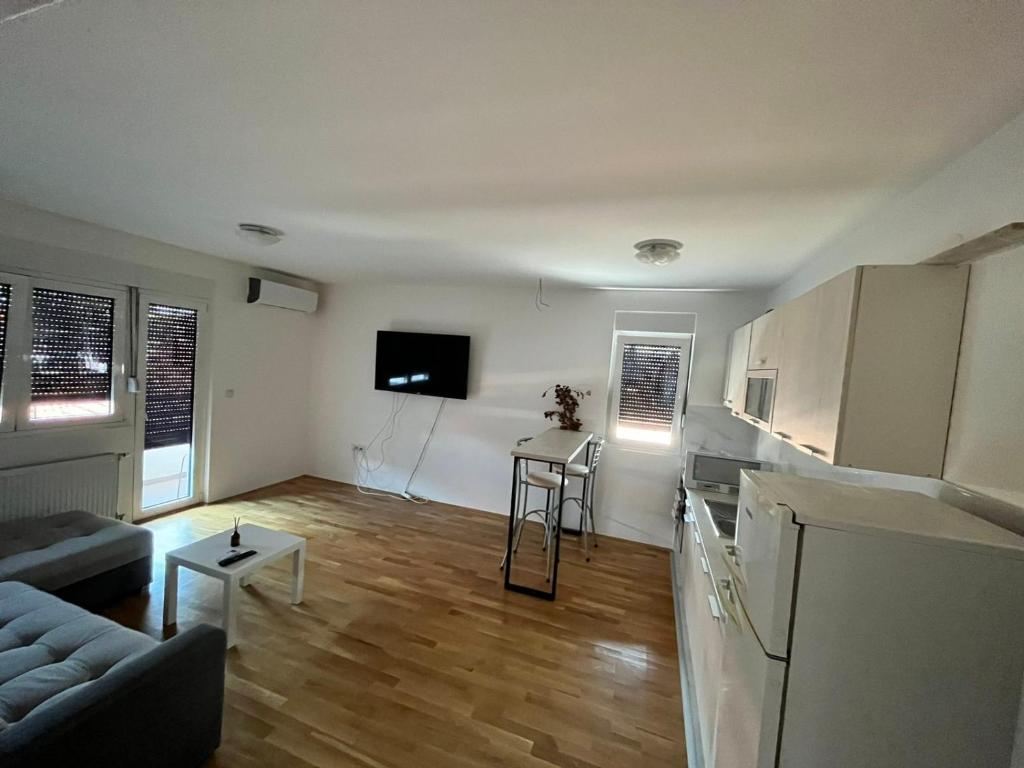 a living room with a couch and a kitchen at San snova apartmani Niš in Donja Vrežina