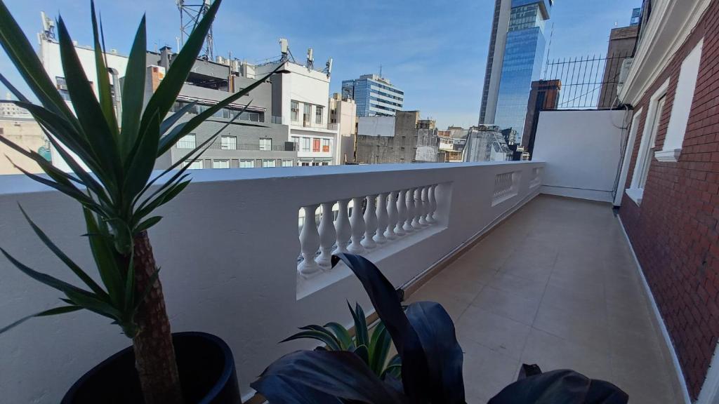 a balcony with a plant on the side of a building at King's Hotel in Buenos Aires