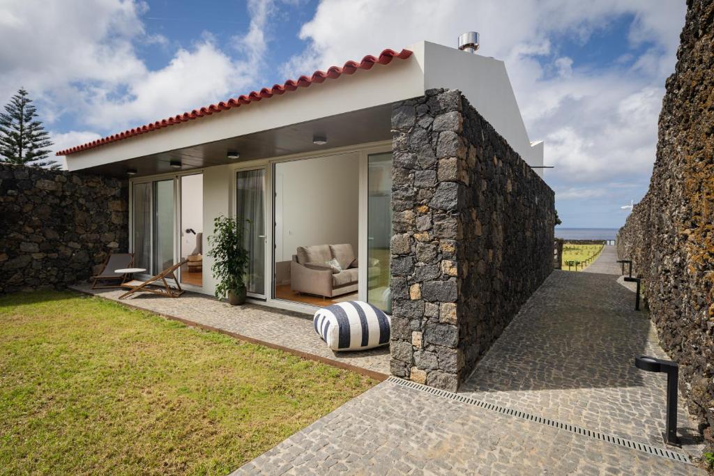 uma casa com uma parede de pedra em ENTRE MUROS - Turismo Rural - Casa com jardim e acesso direto ao mar em Ribeira Grande