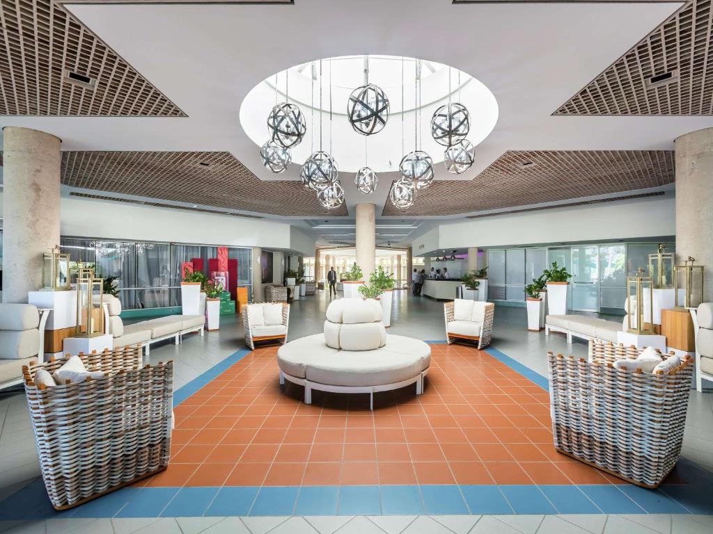 a lobby with chairs and a chandelier at Hilton Ponce Golf & Casino Resort in Ponce