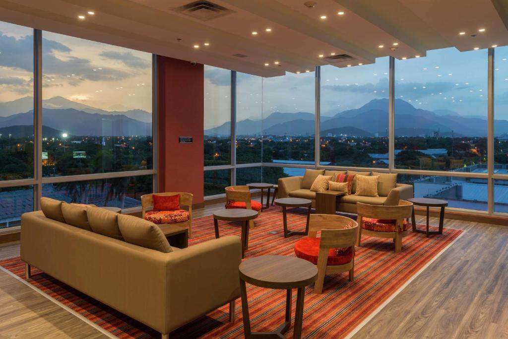 a room with couches and tables and large windows at Hampton By Hilton Valledupar in Valledupar