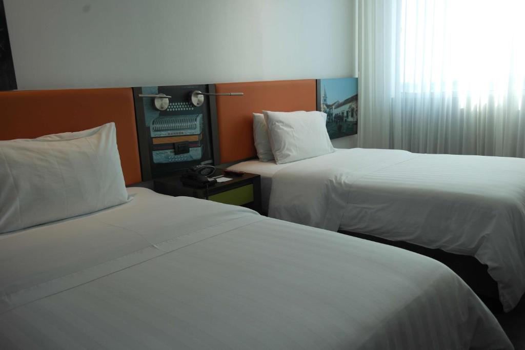 a hotel room with two beds with white sheets at Hampton By Hilton Valledupar in Valledupar