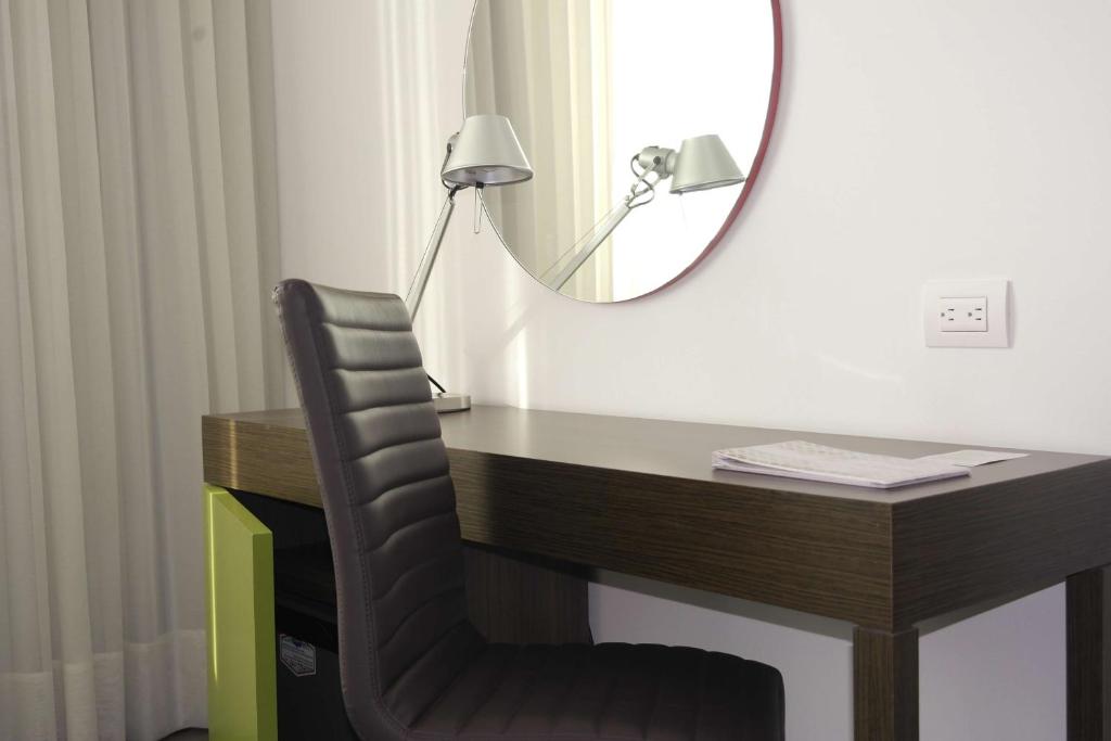 a desk with a chair and a mirror at Hampton By Hilton Valledupar in Valledupar