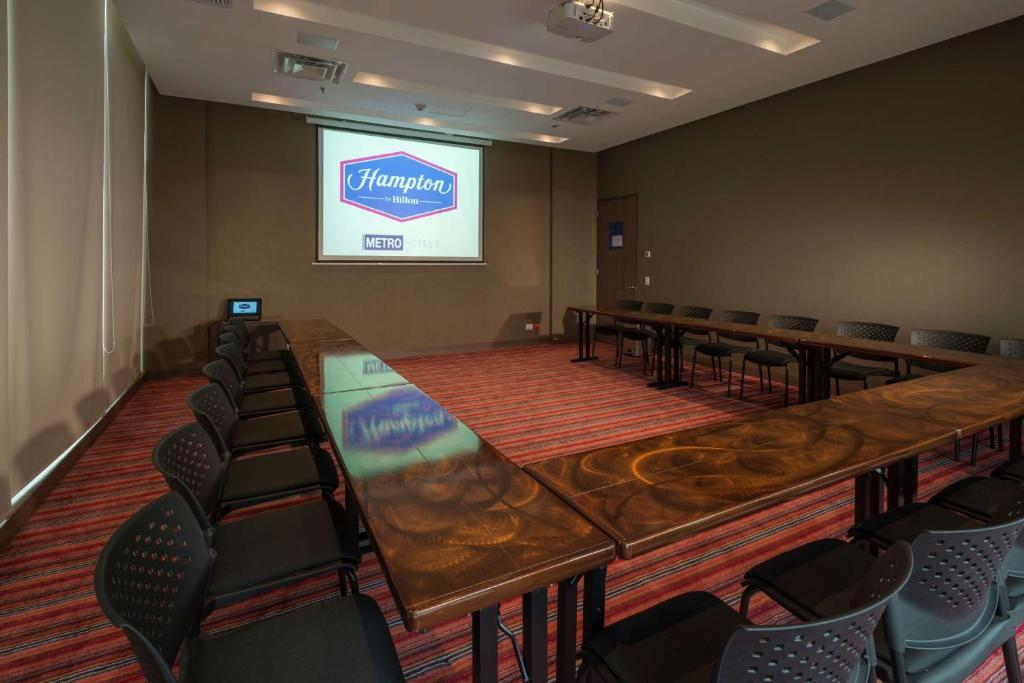 a conference room with tables and chairs and a screen at Hampton By Hilton Valledupar in Valledupar