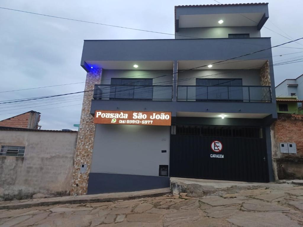 un edificio con un cartello sul lato di Pousada São João a São Thomé das Letras