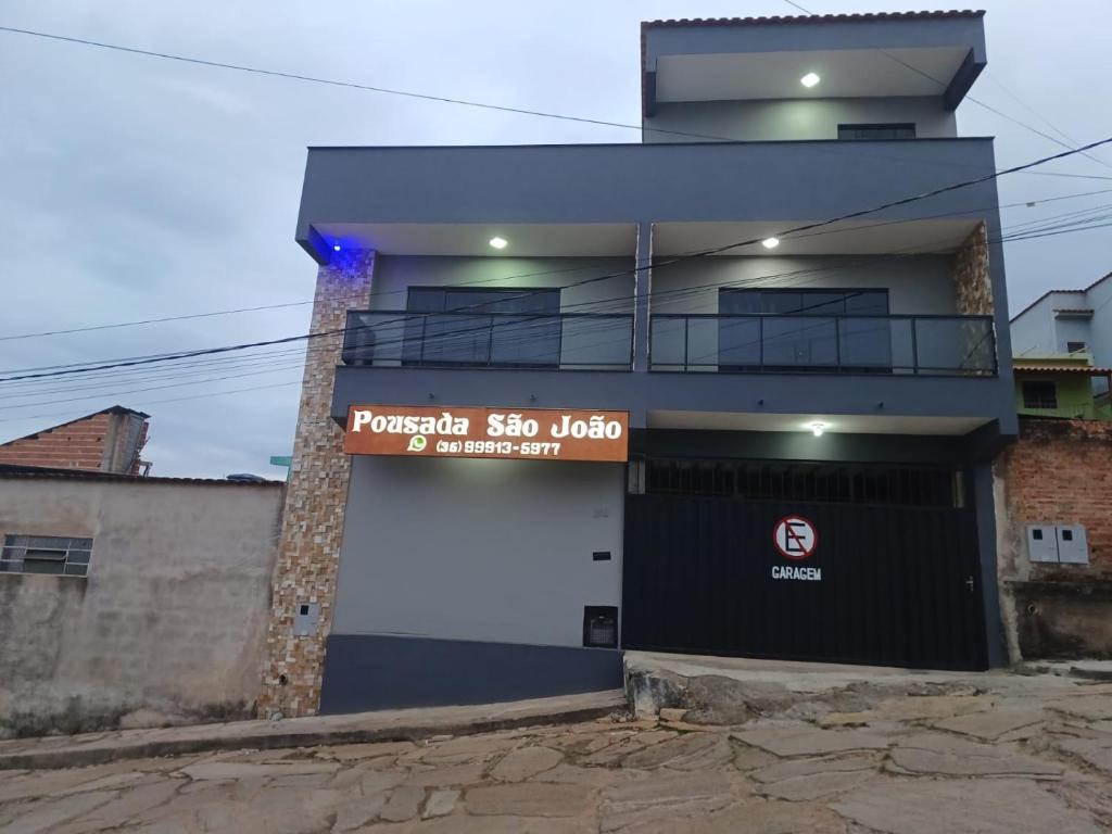 a building with a sign on the side of it at Pousada São João in São Thomé das Letras