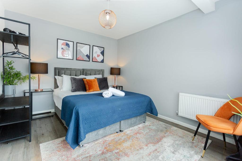 a bedroom with a bed with blue sheets and orange pillows at Free Parking 5 Minutes from City Centre in Manchester