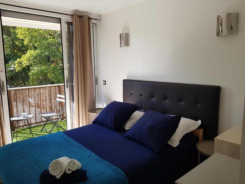 a bedroom with a blue bed with two towels on it at Chez Lisa & Olivier in Athis-Mons