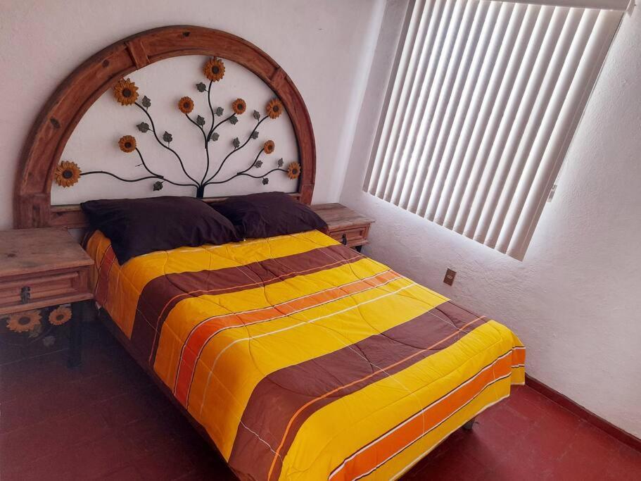 a bedroom with a bed with a wooden head board at Casa completa en Zapopan in Guadalajara