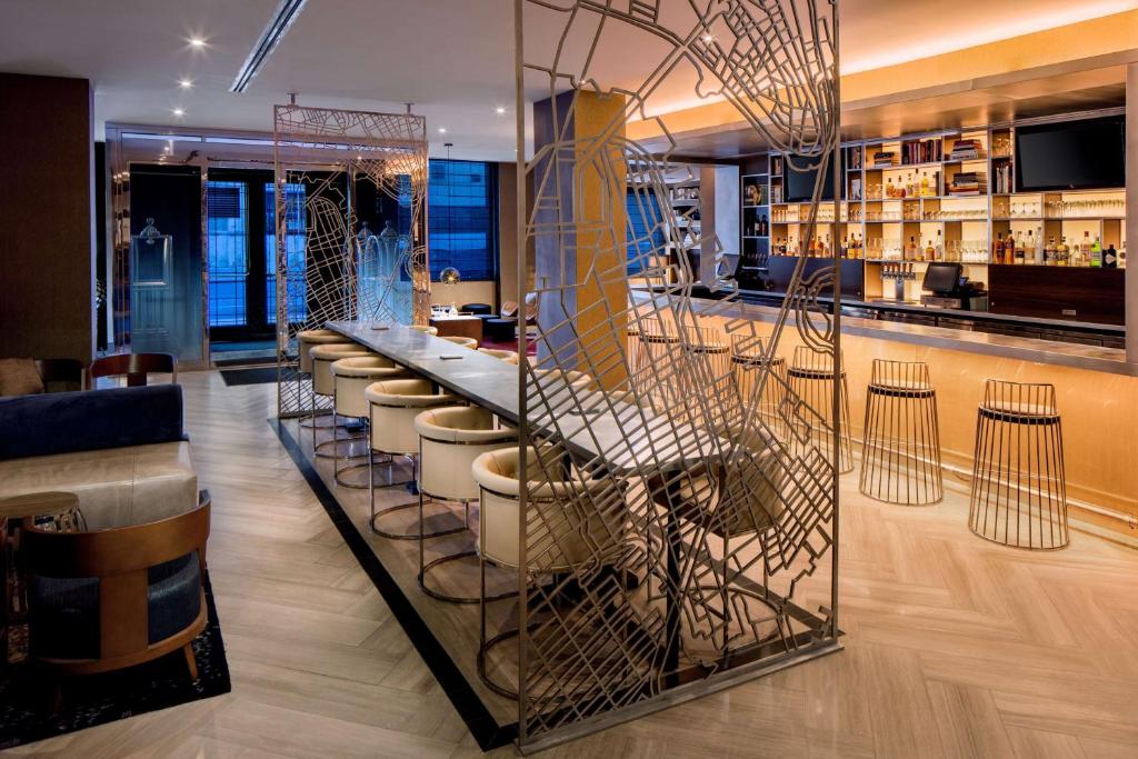 a bar with a row of stools in a restaurant at Hilton Brooklyn New York in Brooklyn