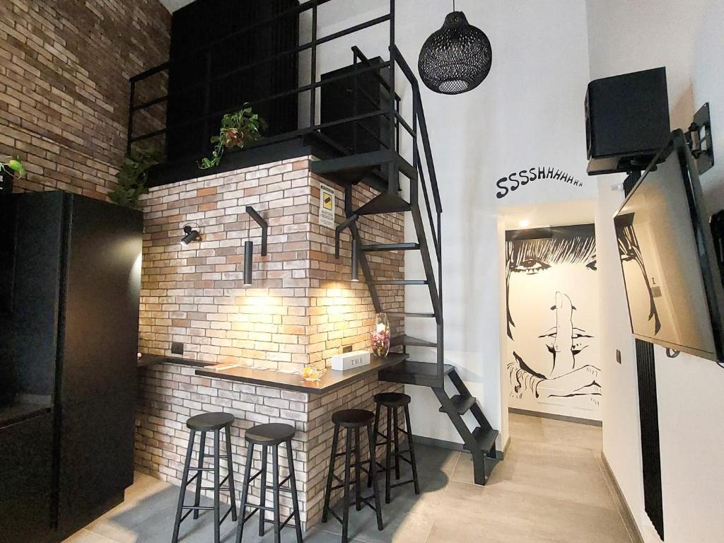 パレルモにあるSant'Andrea - Luxury Rooms in Vucciriaの煉瓦造りの暖炉(スツール付)が備わる部屋