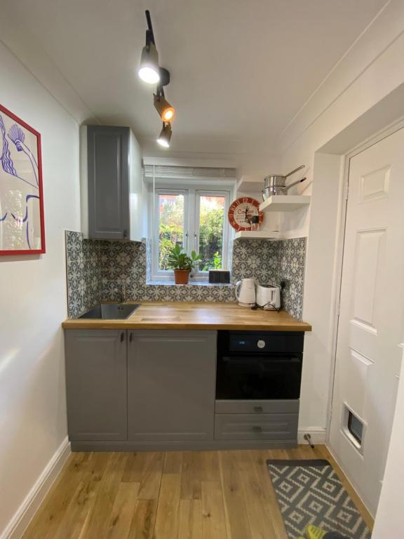 uma cozinha com um lavatório e uma bancada em Stylish 1-bed studio em Londres