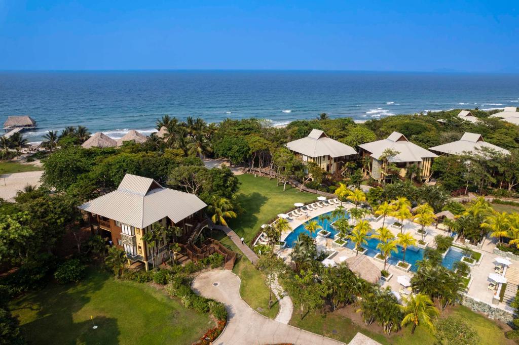 an aerial view of a resort with a swimming pool and the ocean at Indura Beach & Golf Resort Curio Collection By Hilton in Tela