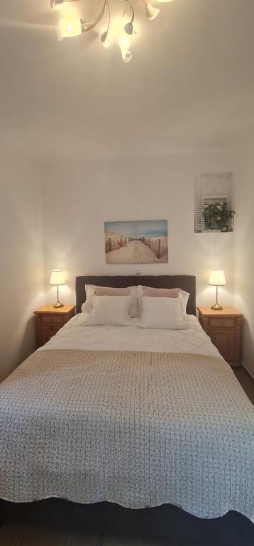 ein Schlafzimmer mit einem großen weißen Bett mit zwei Lampen in der Unterkunft Relax oasis near Split in Vranjic
