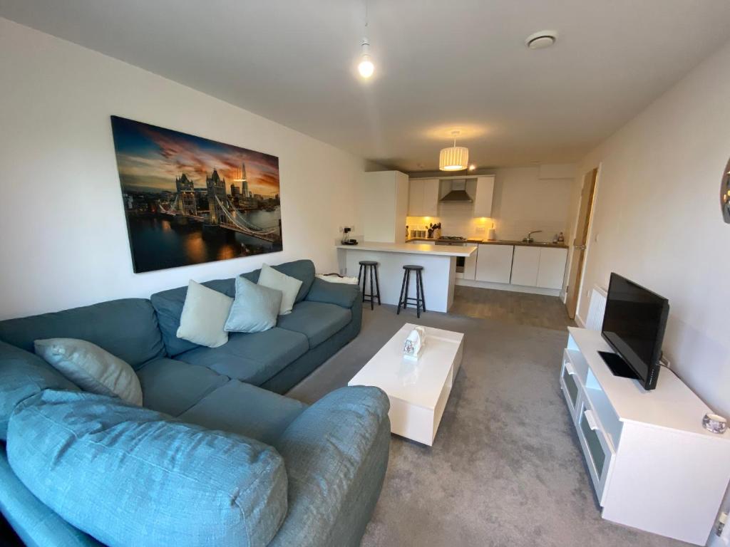 a living room with a blue couch and a tv at Spacious Flat in Central Street in Street
