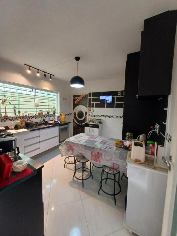 uma cozinha com uma mesa e algumas cadeiras em Suíte privativa em casa de família em São Paulo