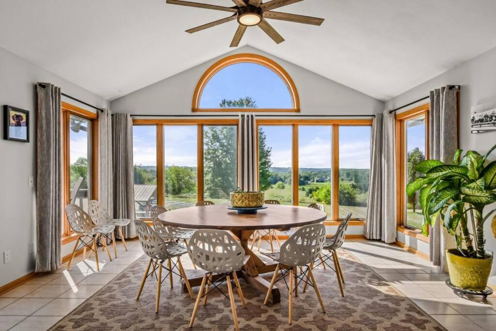 a dining room with a table and chairs and a large window at Country Oasis 