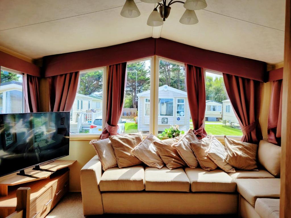 a living room with a couch and a large window at Lyons Robin Hood Holiday Park, The Shamrock Way in Meliden