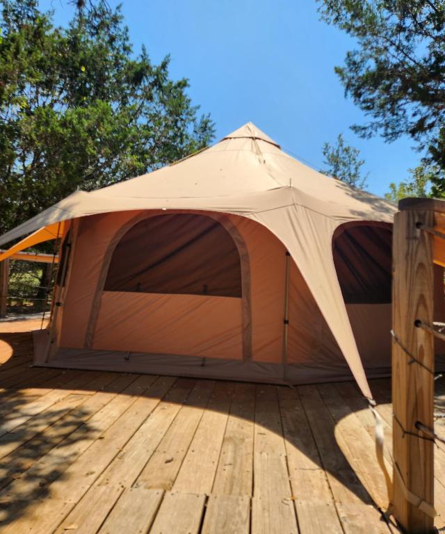 Pipe Creek的住宿－Al's Hideaway Glamping Tents，木甲板上的一个帐篷