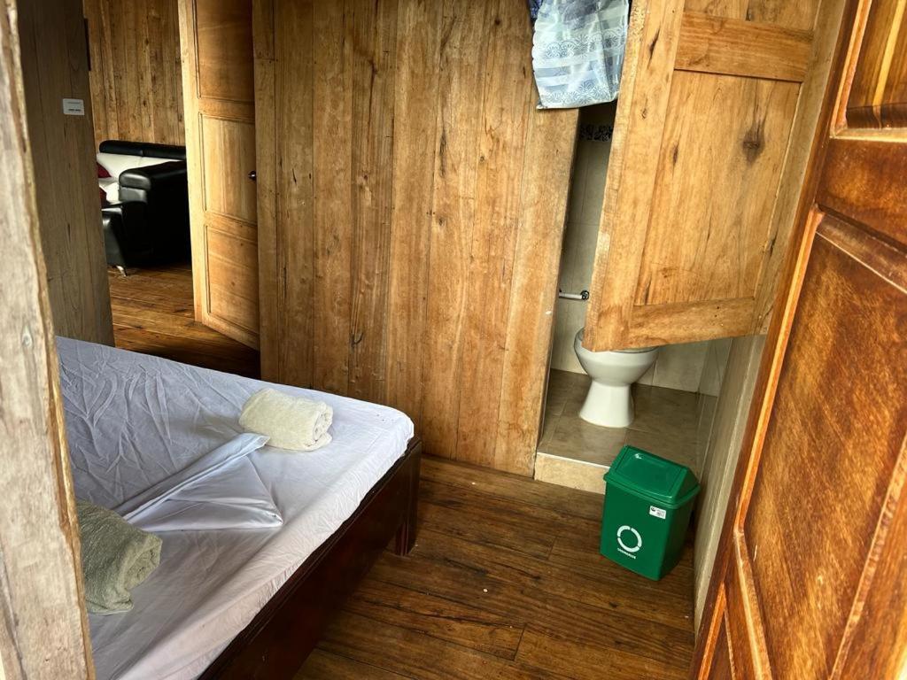 a small room with a bed and a toilet at Cabaña La Marea in Bahía Solano