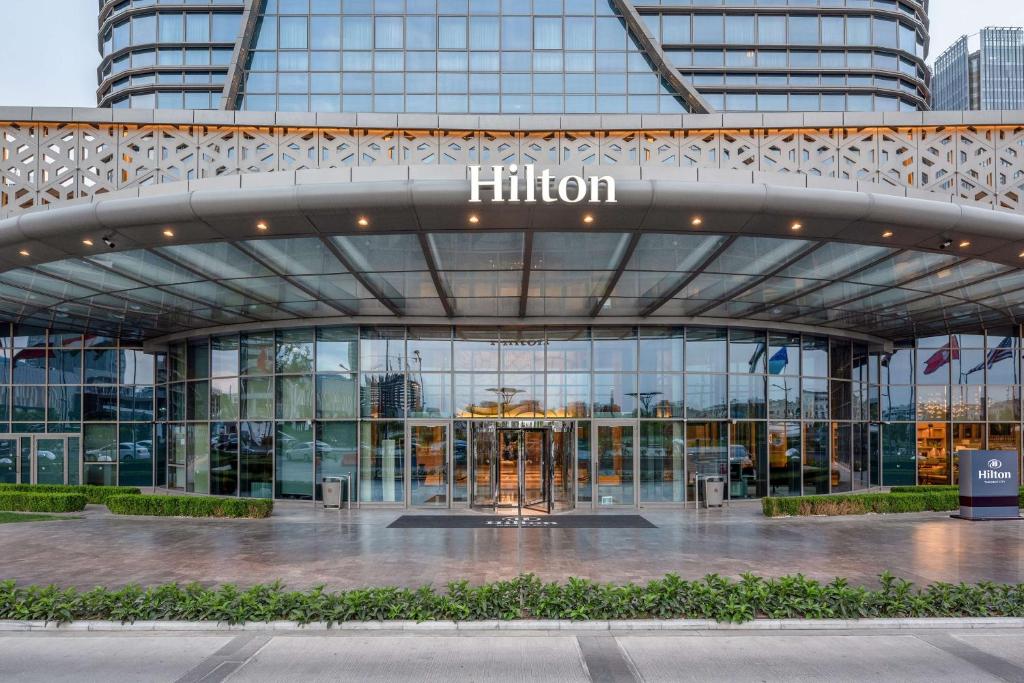 a building with a sign that reads hilton at Hilton Tashkent City in Tashkent