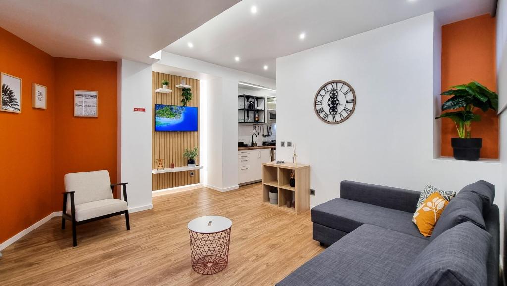a living room with a couch and a kitchen at The Jolie - Apartments by the Ocean in Porto Moniz
