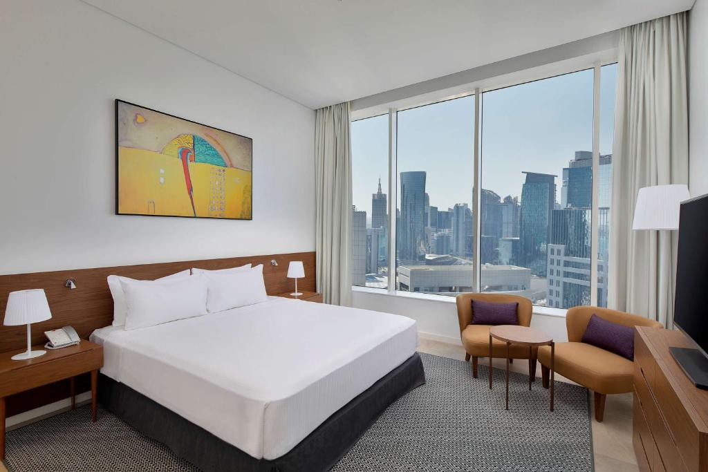 Rúm í herbergi á Aleph Doha Residences, Curio Collection By Hilton