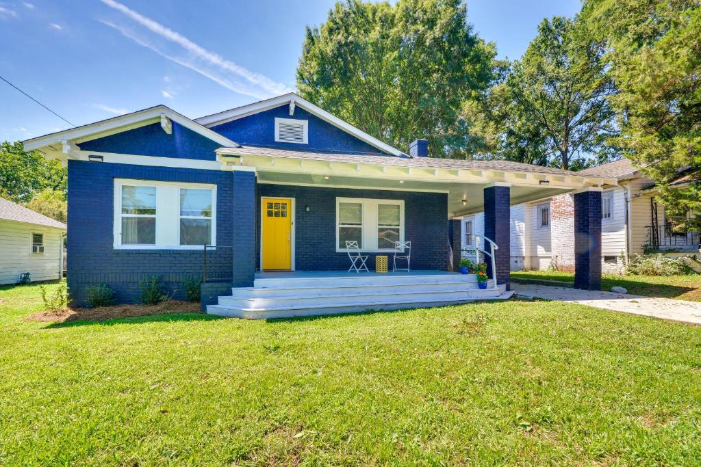 una casa azul con una puerta amarilla y un patio en High Point Vacation Rental with Private Deck and Yard!, en High Point