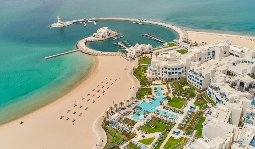 an aerial view of a beach with buildings and the ocean at Hilton Salwa Beach Resort and Villas 