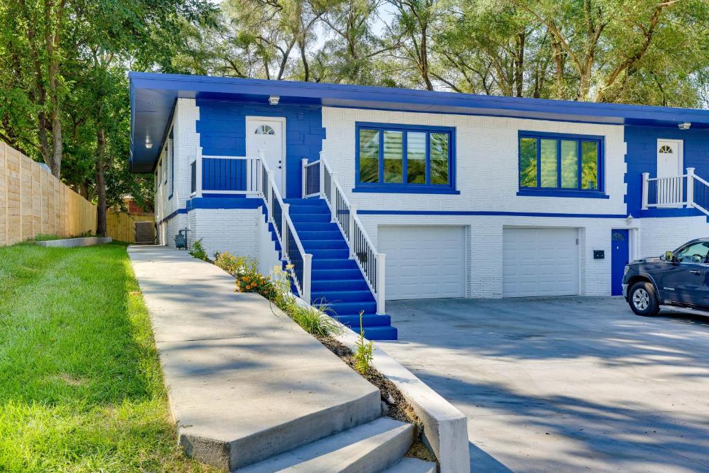 una casa azul y blanca con entrada en Charming Omaha Getaway - 3 Mi to Baxter Arena! en Omaha