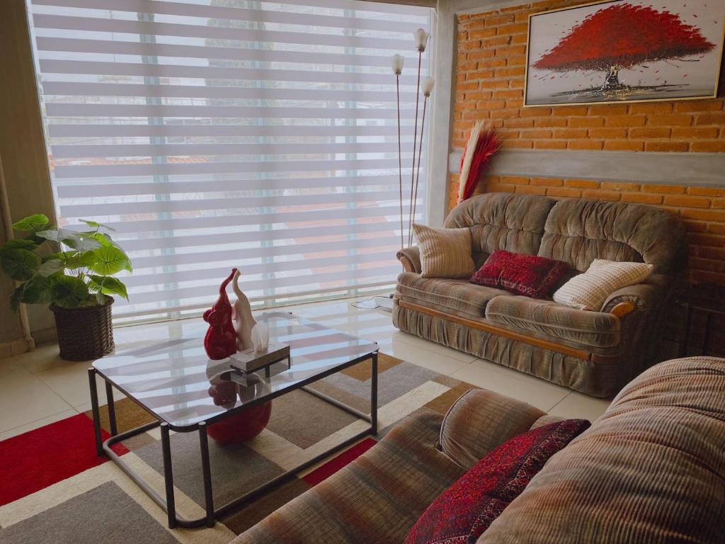 a living room with a couch and a glass table at Depto Nuevo cerca del foro sol "Andy" in Mexico City