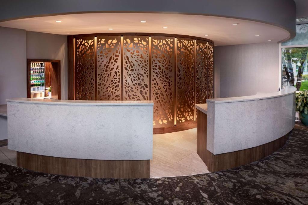 a lobby with a reception counter and a wall of wood at Embassy Suites by Hilton Boston Marlborough in Marlborough