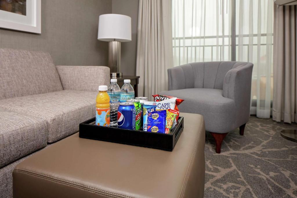 a living room with a couch and a table with drinks at Embassy Suites by Hilton Boston Marlborough in Marlborough