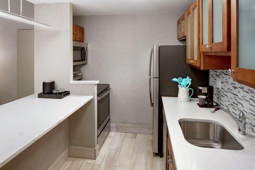 a small kitchen with a sink and a refrigerator at Embassy Suites by Hilton Boston Marlborough in Marlborough