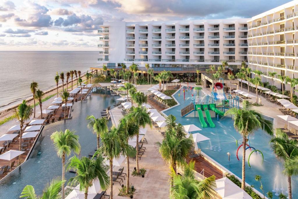 an aerial view of the resort with a swimming pool and the ocean at Hilton Cancun, an All-Inclusive Resort in Cancún