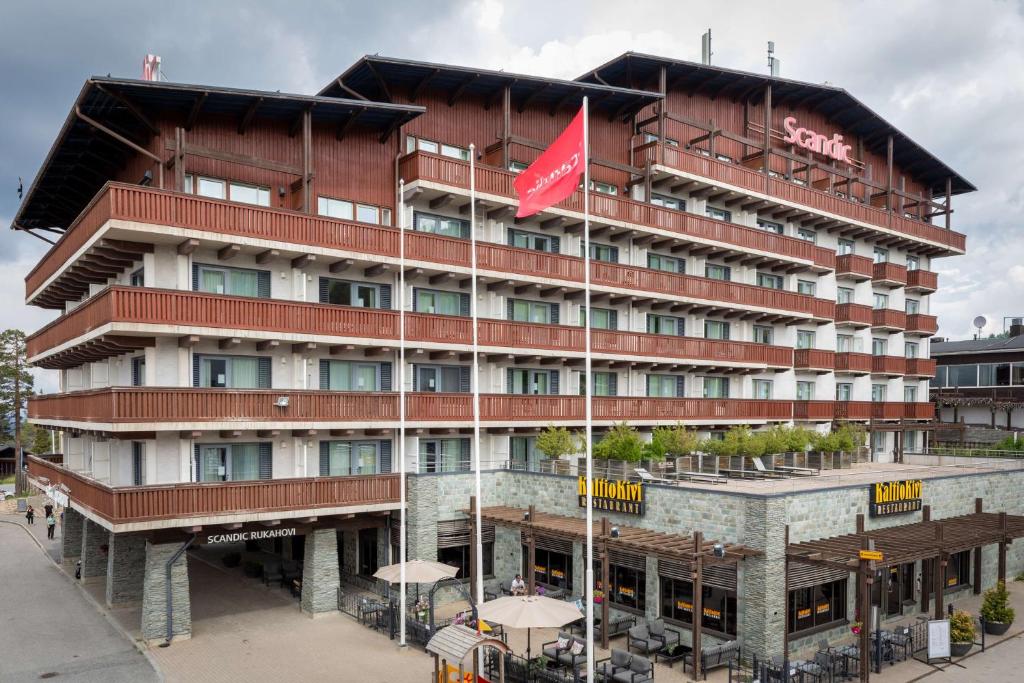 un hotel con una bandera roja delante de él en Scandic Rukahovi en Ruka