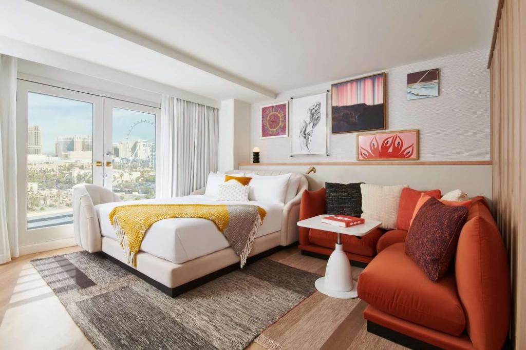 Un dormitorio con una cama, un sofá y una silla. en Virgin Hotels Las Vegas, Curio Collection by Hilton, en Las Vegas