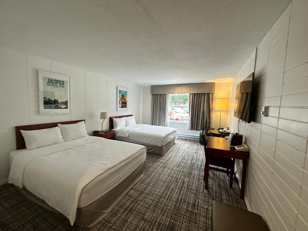 a hotel room with two beds and a desk at August Jack Motor Inn in Squamish