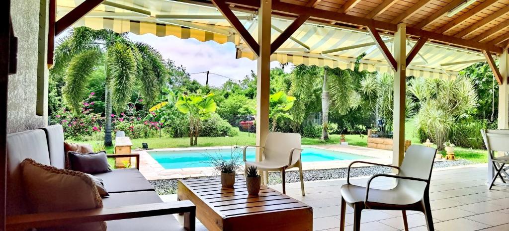 une terrasse avec une table, des chaises et une piscine dans l'établissement Cocooning Paradise, à Saint-François