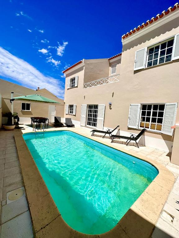 a swimming pool in front of a house at A Villa Fortuna in Santo André