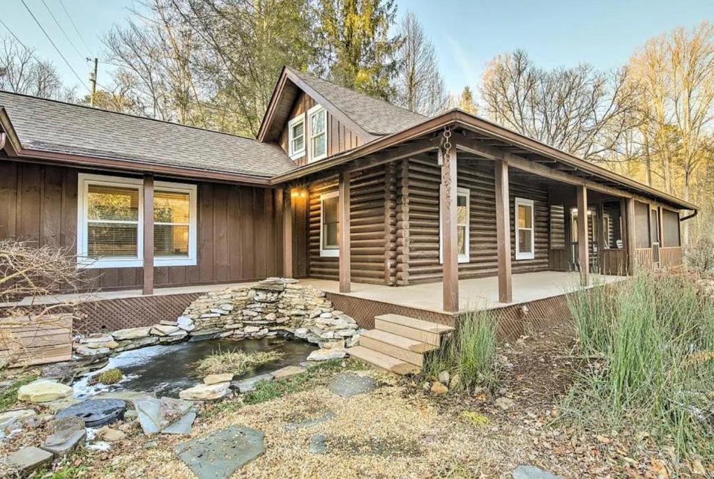 a log home with a pond in front of it at Smokey Mountain Hideaway in Gatlinburg