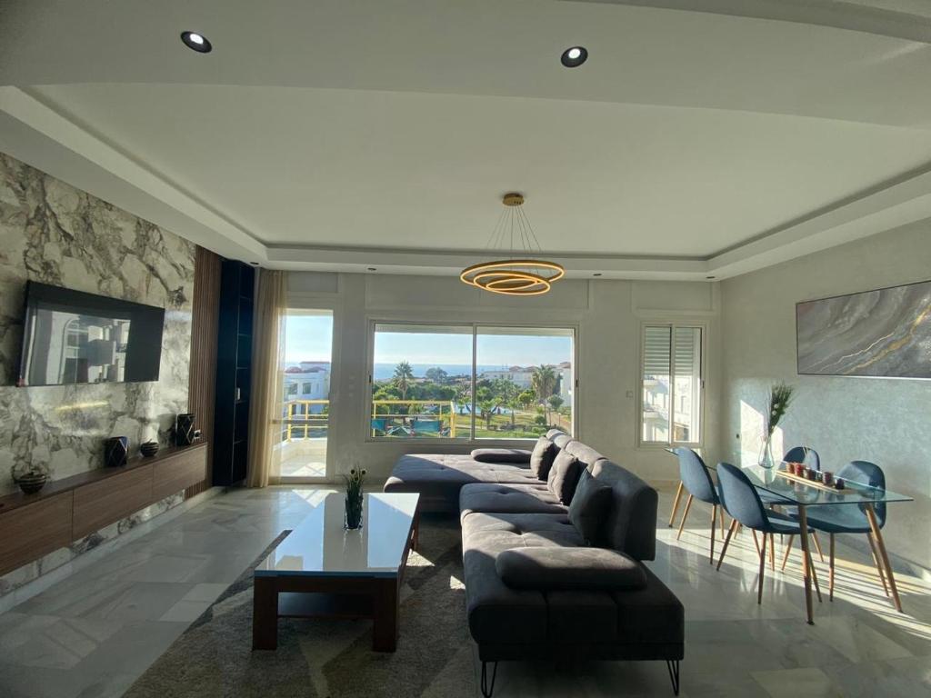 uma sala de estar com um sofá e uma mesa em luxury condo with sea view em Tânger