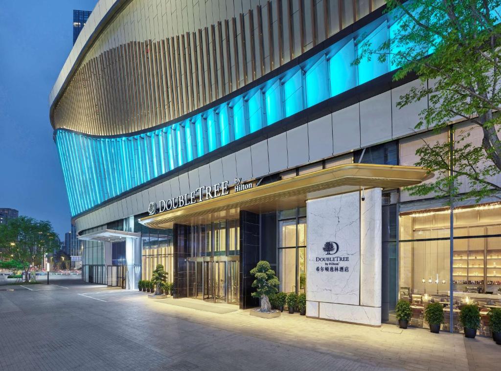 eine Fassade eines Gebäudes mit blauen Lichtern in der Unterkunft DoubleTree By Hilton Chengdu Riverside in Chengdu